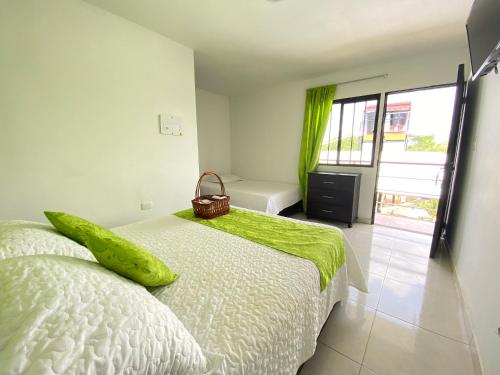 a bedroom with a bed with a green blanket on it at HV Sueño Real Tatacoa in Villavieja