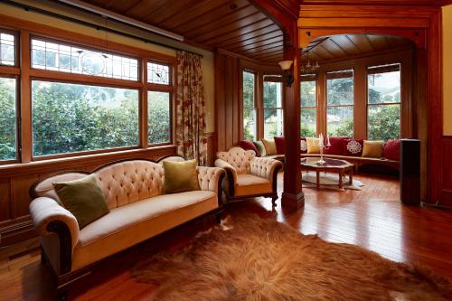 a large living room with couches and windows at Kaituna Valley Homestead in Little River