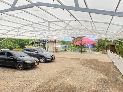two cars are parked under a metal roof at HV Sueño Real Tatacoa in Villavieja
