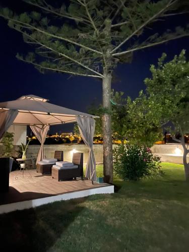 a gazebo with a table and chairs on a deck at night at Kerart House in Armação de Pêra