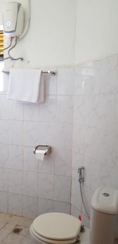 a bathroom with a toilet and a towel on the wall at Northern Pearl in Gulu