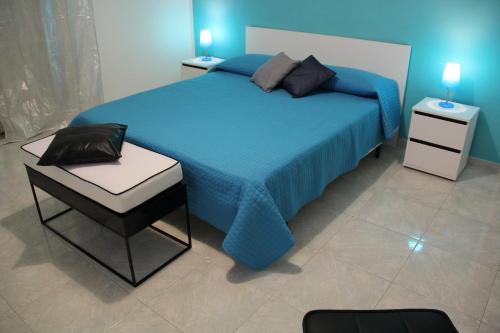 a bedroom with a blue bed and two night stands at Camere Amarzè Plus in Portopalo