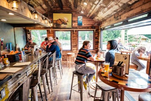 a group of people sitting at tables in a restaurant at Hope Alaska's Bear Creek Lodge in Hope