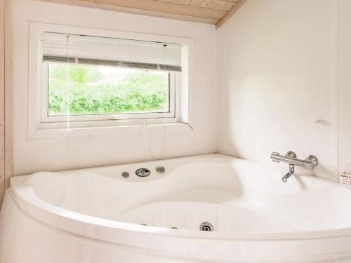 a white bath tub in a bathroom with a window at Four-Bedroom Holiday home in Gilleleje 1 in Gilleleje