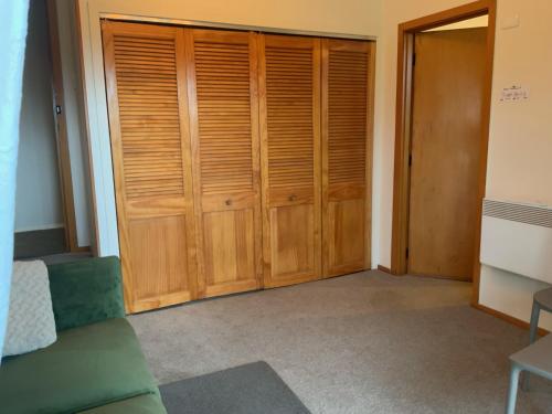 a room with wooden closets and a green couch at Brook House B&B & Cottages in Kaikoura