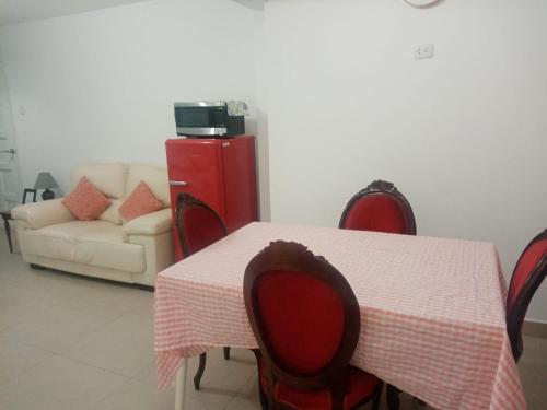a table and chairs with a table and a couch at Strenua - Las Quintanas in Trujillo