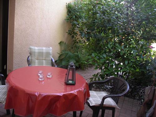 a red table with chairs and a lantern on a patio at Ferienwohnung Herrig in Treis-Karden