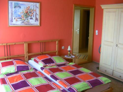 ツィノヴィッツにあるFerienhaus Lukasの赤い壁のベッドルーム1室(ベッド2台付)