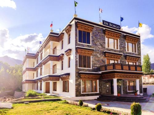 a hotel in the mountains with a building at Hotel de borgo in Leh