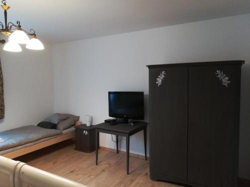 a living room with a couch and a tv at Cinege Vendégház in Tolcsva