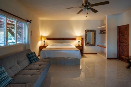 a living room with a bed and a couch at The Diving Lodge Downtown in Puerto Morelos