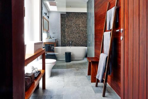 a bathroom with a tub and a toilet and a sink at Villa Ziba in Seminyak