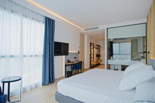 ein Schlafzimmer mit einem weißen Bett und einem großen Fenster in der Unterkunft Syncrosfera Fitness & Health Hotel Boutique in Pedreguer