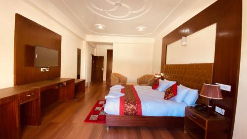 a hotel room with a bed and a flat screen tv at Hotel de borgo in Leh