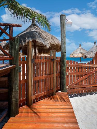 a wooden boardwalk on the beach with umbrellas at The Diving Lodge Downtown in Puerto Morelos