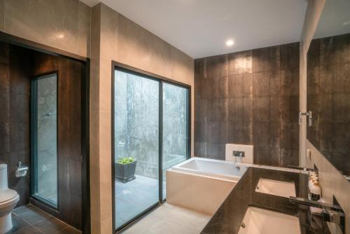 a bathroom with a bath tub and a toilet at Layantara Villas in Layan Beach