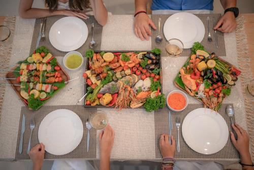 a group of people sitting at a table with plates of food at Layantara Villas in Layan Beach