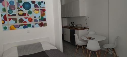 a small kitchen with a table and two white chairs at Studio Ena in Neoi Epivates