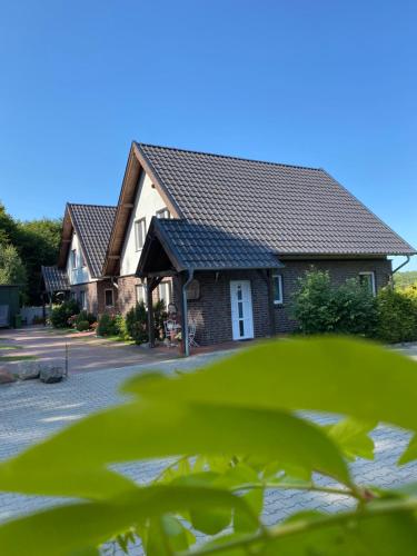 a house with a shingled roof at Lesny Apartament in Ostrzyce