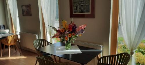 a dining room table with a vase of flowers on it at 23-hotel in Schwadorf