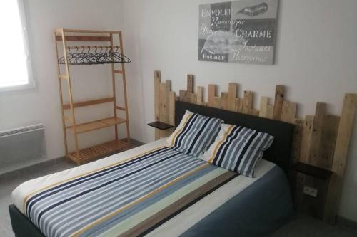 a bed with a wooden headboard in a room at Home sweet home en Bord de Mer in Camiers