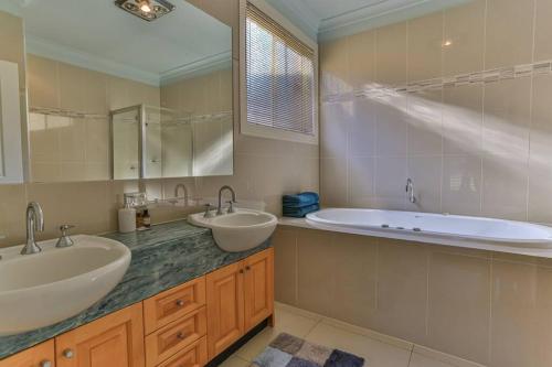 a bathroom with two sinks and a bath tub at Ventnor Escape in Style in Ventnor