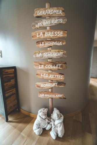 Deux ours en peluche sont assis devant un panneau dans l'établissement le coup de soleil, à Gérardmer