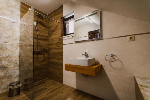 a bathroom with a sink and a shower at Pensiunea Trecatoarea Lupilor in Burda