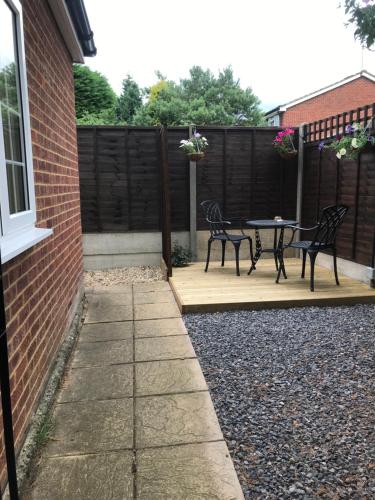a patio with two black chairs and a table at Studio-1-Staines/Heathrow/London-own entrance in Staines