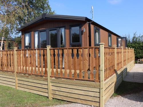 a small house with a wooden fence at Hawthorn Lodge in Carnforth