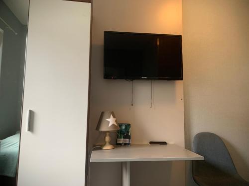 a room with a table and a tv on a wall at landpension-dette in Berlingerode