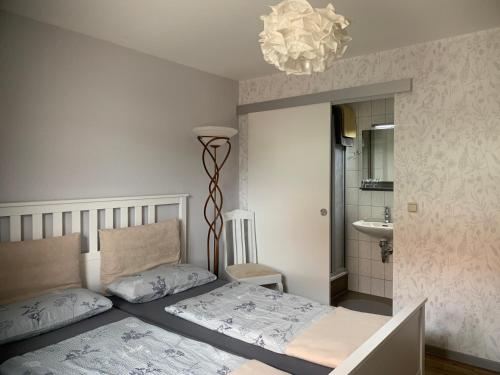 1 dormitorio con cama y lámpara de araña en landpension-dette, en Berlingerode