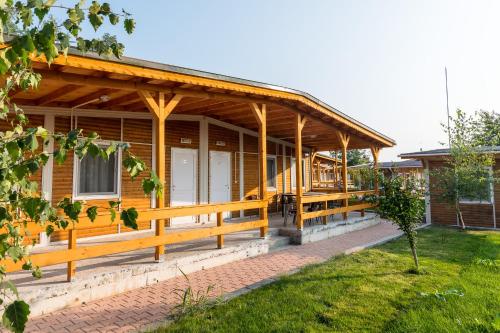 a wooden house with a porch and a yard at Villa Trakia in Simeonovo