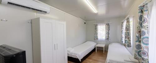 a small white room with a bed and a tv at Villa Trakia in Simeonovo
