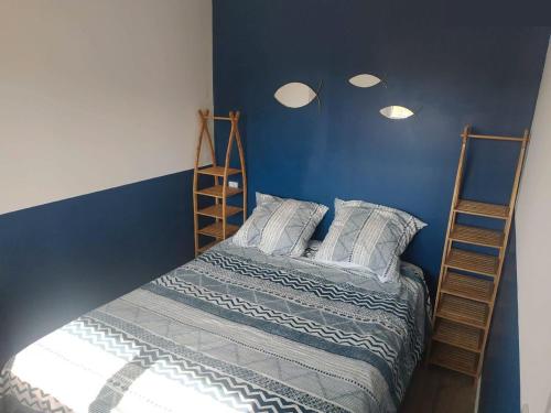 パトリモニオにあるCharmant appartement F2 neuf Patrimonioの青い壁のベッドルーム1室(二段ベッド2組付)