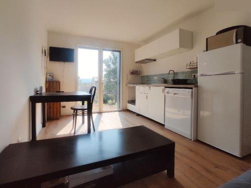 una cucina con frigorifero bianco e tavolo di Charmant appartement F2 neuf Patrimonio a Patrimonio