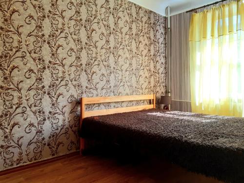 a bedroom with a bed with a damask wallpaper at Большая Перспективная 46 in Kropyvnytskyi