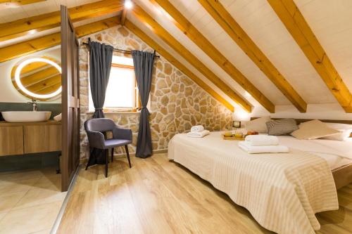 a attic bedroom with two beds and a bathroom at Villa Humac Hvar in Poljica