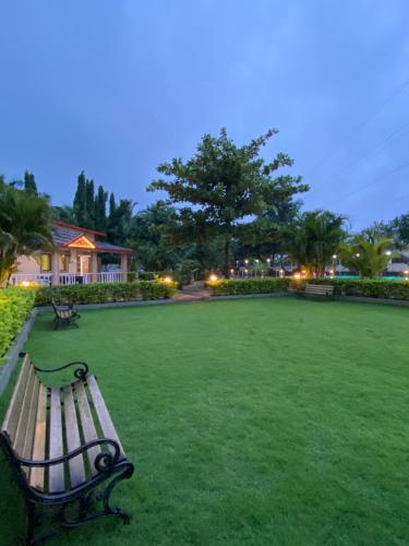 a park bench sitting in the middle of a field at Karjat retreat 4bhk pvt farmhouse in Karjat