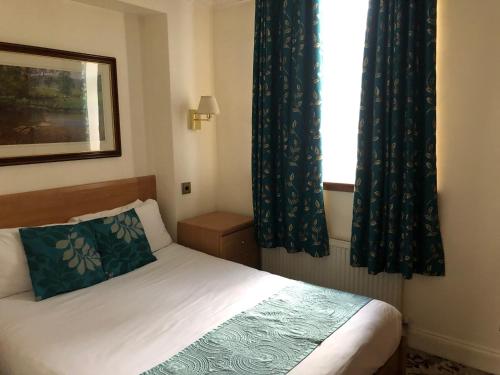a small bedroom with a bed and a window at Abbey Court Hotel - Hyde Park in London