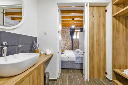 a bathroom with a white sink and a bedroom at Villa Humac Hvar in Poljica