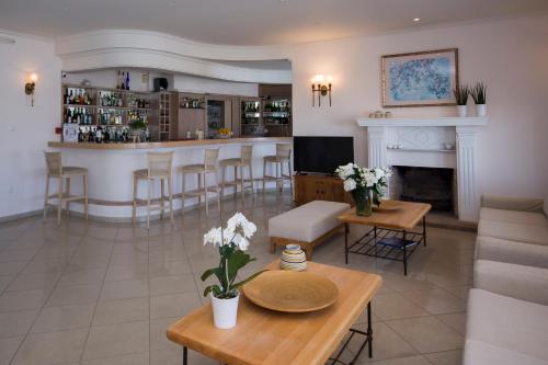 a living room with a fireplace and a bar at Hotel Adonis in Mýkonos City