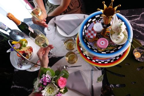 Boutique Hotel K7 في باد ناوهايم: طاولة مع طبق من الطعام والناس الذين يحملون كؤوس النبيذ