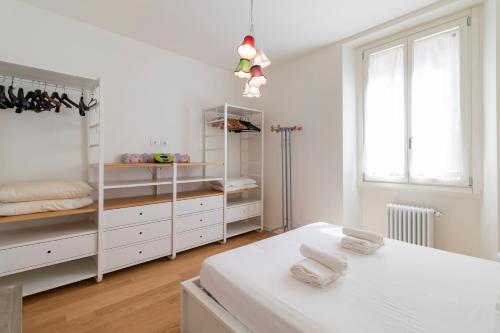 een witte slaapkamer met witte planken en een bed bij Cosy 1-bed near Milano Centrale in Milaan