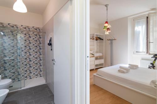 een witte badkamer met een douche en een bed bij Cosy 1-bed near Milano Centrale in Milaan