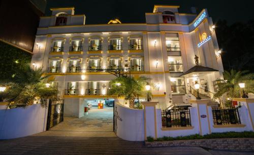 a large white building with lights on it at night at Sterling Marbella Dehradun in Dehradun