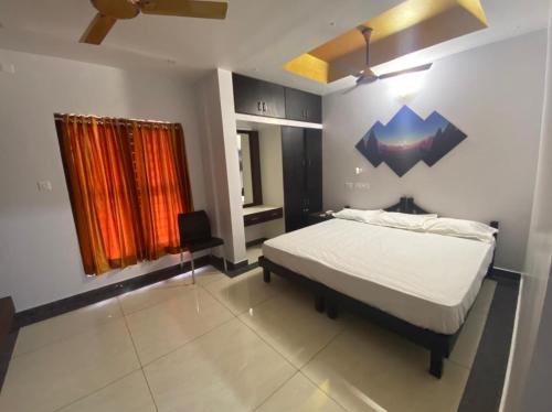 sypialnia z łóżkiem i obrazem na ścianie w obiekcie PLANET RESIDENCY w mieście Thiruvananthapuram