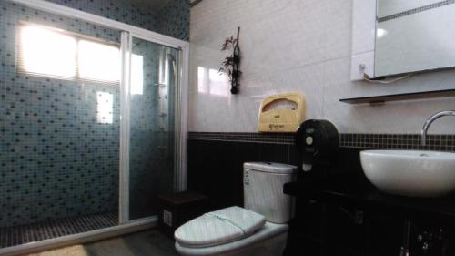 a bathroom with a toilet and a sink and a shower at Hua Qing Yuan in Yuanshan