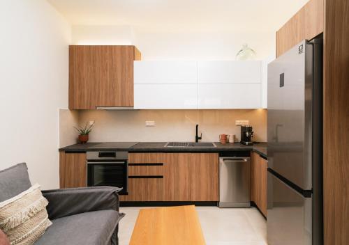 a kitchen with wooden cabinets and a stainless steel refrigerator at ROOF GARDEN SUITE in Matala