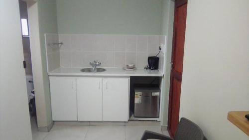 a small kitchen with a sink and a microwave at Emampingeni lodge in Bizana